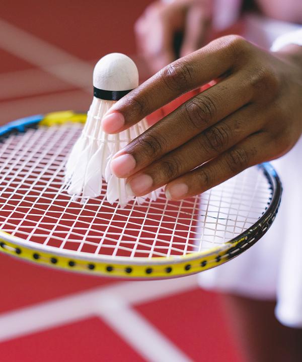 Image of womans hand with badminton bat and shuttle cock