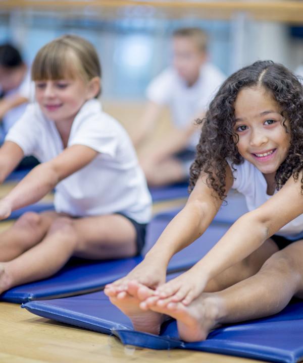 Image of young girl with curly hair touching her toes