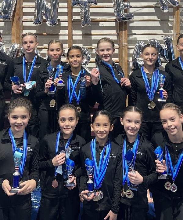 Gymnastics competitors holding medals