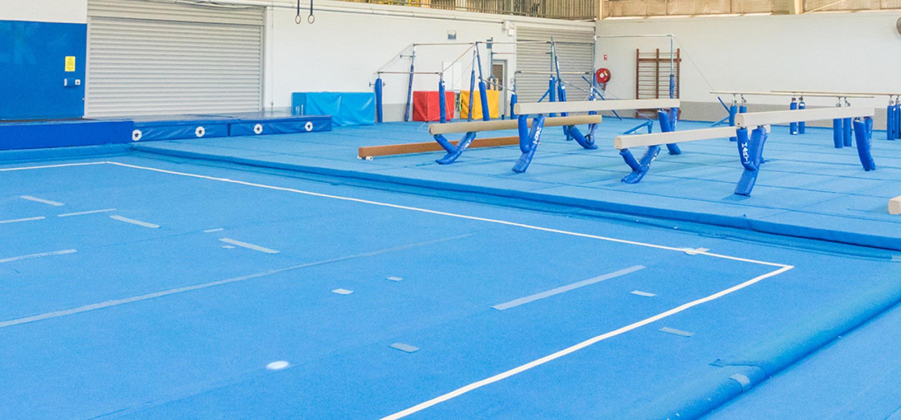 Gym room, soft floor and gymnastics equipment.