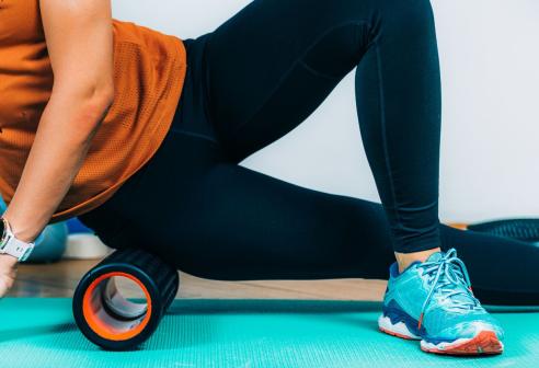 Woman using foam roller on leg