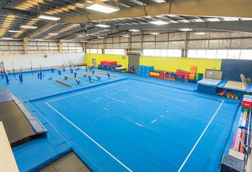 Image of large indoor gymnastics centre with beams and foam mats