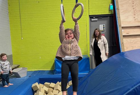 young girl hanging over foam pit